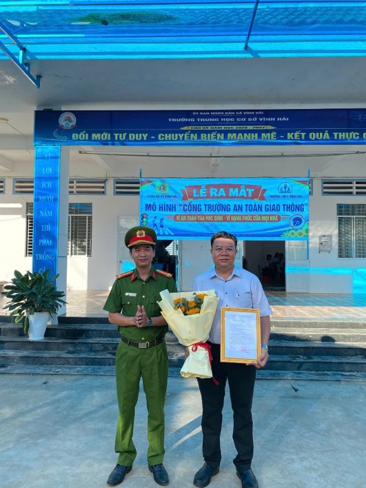 Thừa ủy quyền của Chủ tịch UBND xã, đồng chí Trung tá Đặng Hoàng Phúc, Trưởng Công an xã trao Quyết định của UBND xã về việc thành lập mô hình cho Hiệu trưởng trường THCS Vĩnh Hải